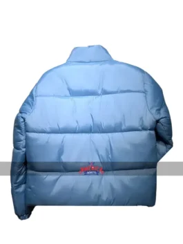 Back view of the light blue Andy Cohen Jacket, a stylish puffer jacket featuring horizontal quilting and a high collar for a trendy winter look.