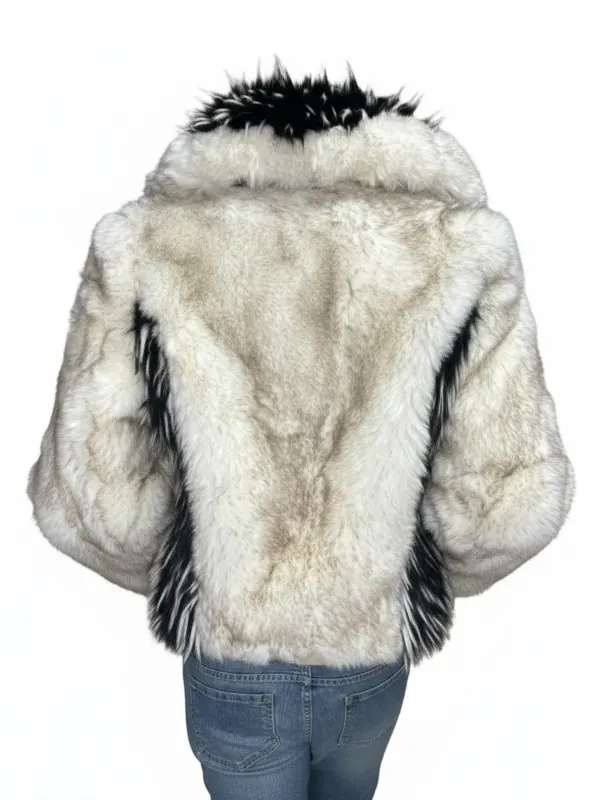 Rear view of a plush cream jacket on a mannequin showing subtle dark vertical framing panels along the sides and a prominent high collar.
