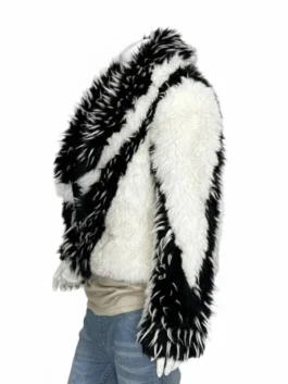 shaggy two-tone jacket with thick white and black multi-textured panels worn over a beige top and jeans.