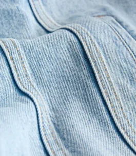 Close-up of durable fabric on a Women Light Blue Denim Jacket. Detailed texture of this cheap Light Blue denim jacket highlights its premium quality.
