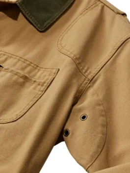 Close-up of a Men's Cotton Brown Jacket showing the durable fabric texture, reinforced shoulder stitching, and metal underarm ventilation eyelets.