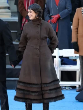 Rama Duwaji 2026 Coat front view on blue carpet showing high collar, covered buttons, and fur-trim hem