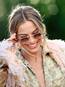 Close-up of Margot Robbie Wuthering Heights London look, featuring tinted sunglasses and the feathered collar of her John Galliano coat.