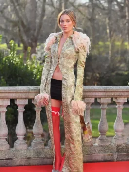 Actress Margot Robbie in her Wuthering Heights press tour coat by John Galliano, showcasing the intricate long trim coat design.