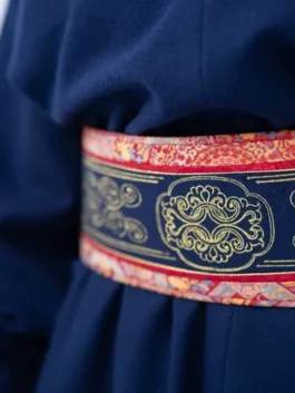Close-up of the ornate belted deel mens outfit for the Milano Cortina 2026 Mongolia ceremonial uniform, showing gold patterns on a navy blue sash.