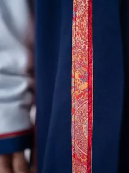 Close-up of the Mongolia opening ceremony uniform womens deel 2026, featuring vibrant red and orange silk embroidery along the robe’s edge.