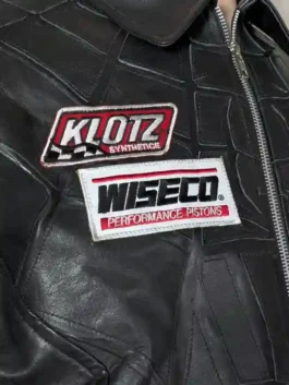 Flat lay of the superhero collaborative leather jacket showing the full-front design and racing patches.