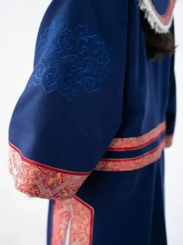Close-up of the embroidered womens deel for Team Mongolia 2026, highlighting the intricate blue needlework on the sleeve of the ceremonial robe.