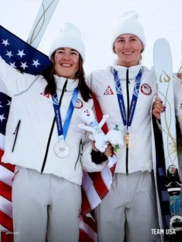 Elizabeth Lemley and Jaelin Kauf on the podium in the official Team USA Olympics 2026 Podim Quilted Puffer Nike Jacket with medals.