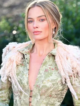 Close-up of Margot Robbie in a John Galliano long feather trim coat, highlighting the pink feathered collar and pearl earrings.