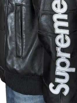 Supreme Vanson Spider-Man black leather jacket sleeve with white Supreme lettering branding and rib-knitted cuff at wrist
