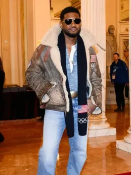 Full view of Usher in the Usher shearling leather jacket Olympics 2026, paired with light wash jeans and a Team USA scarf for the winter games.