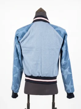 Full rear view of the Adidas Denim Graphic Varsity Bomber Jacket on a mannequin, highlighting the star graphic patterns along both sleeves.