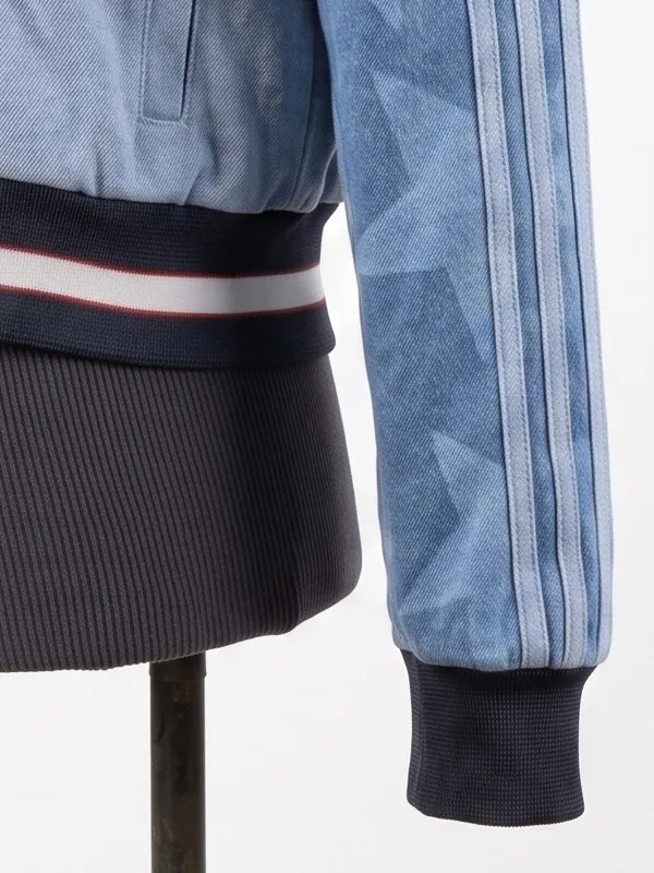 Zoomed-in view of the ribbed knit waistband and cuff on the Adidas Denim Graphic Varsity Bomber Jacket, showcasing the faded star patterns.