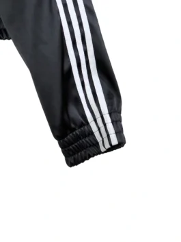 Cropped black fusion coat with white ribbon and sleeve detailing.