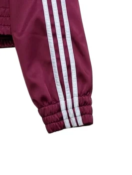 Cropped maroon sports jacket featuring a white ribbon closure.