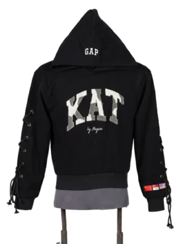 Front view of a loose-fitting black fleece hoodie on a display mannequin featuring structured camo applique chest text and side sleeve grommet ties.