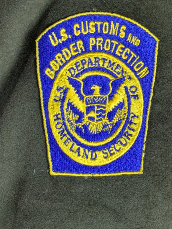Circular blue embroidered uniform patch with a gold border featuring the outline of the United States map and text reading U.S. Border Patrol.