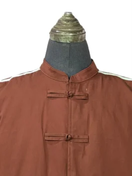Detailed close-up view of the Mandarin collar and upper frog button closure on the brown Adidas CLOT Edison Chen jacket.