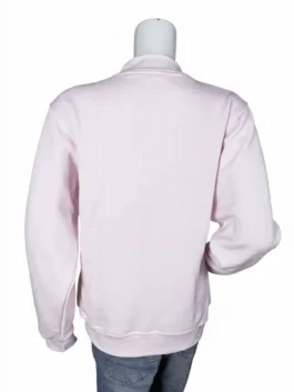 Rear view of a plain pastel pink mockneck sweatshirt on a mannequin paired with blue denim jeans.