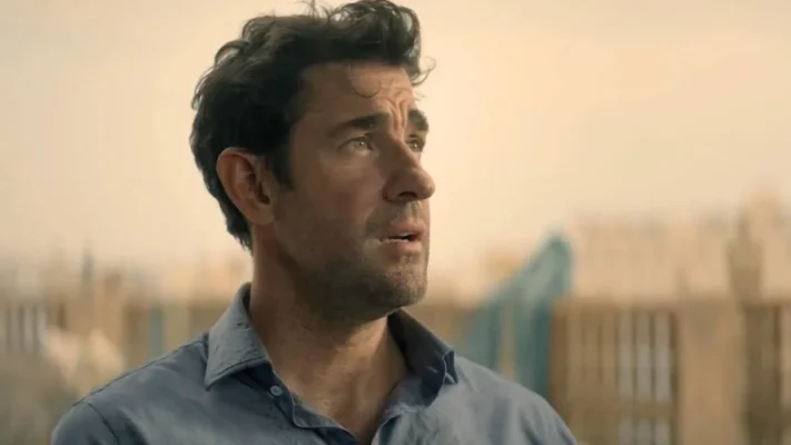 John Krasinski as Jack Ryan standing in a city scene wearing a light blue shirt in Tom Clancy’s Jack Ryan Ghost War 2026