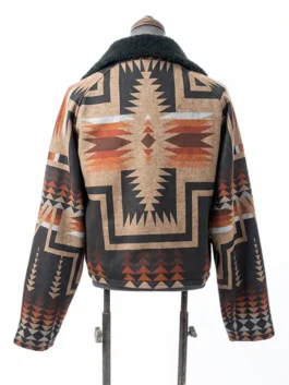 Rear view of the Dutton Ranch Beth Dutton Western Print Jacket on a mannequin, showcasing a large, centered Aztec cross graphic in rust, orange, tan, and black.