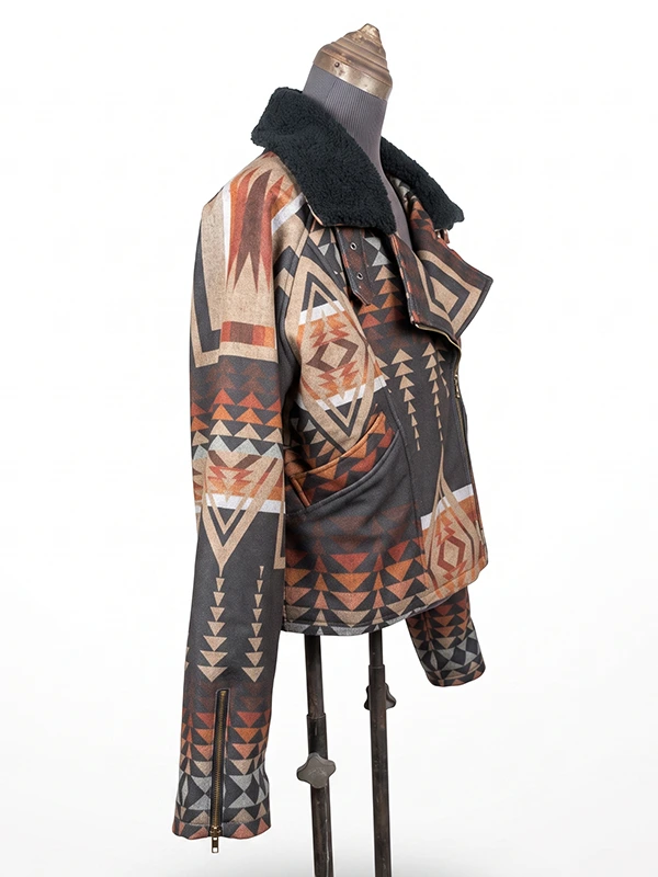 Three-quarter right side view of the Dutton Ranch Beth Dutton Western Print Jacket on a mannequin, highlighting the open asymmetrical collar flap and brass belt loop hardware details.