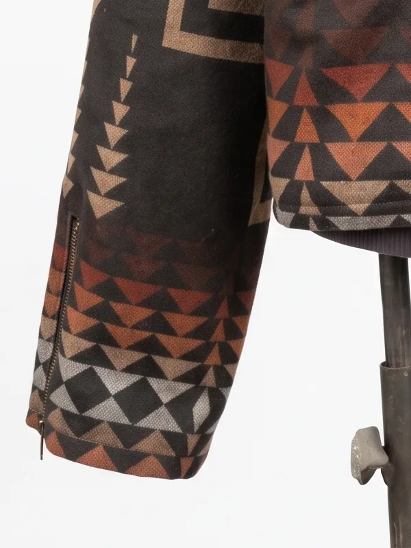 Close-up of the long sleeve on the Dutton Ranch Beth Dutton Western Print Jacket, featuring an integrated vertical wrist zipper and geometric tribal patterns in earth tones.