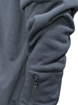 Close-up view of the sleeve on the dark navy blue Airplane Mode Travel Hoodie, highlighting the soft fleece texture and a small functional zipper pocket near the cuff.