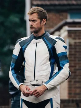 Full front standing view of Alexander Skarsgard wearing a white, blue, and black leather racer jacket with ribbed chest paneling and a waist belt strap