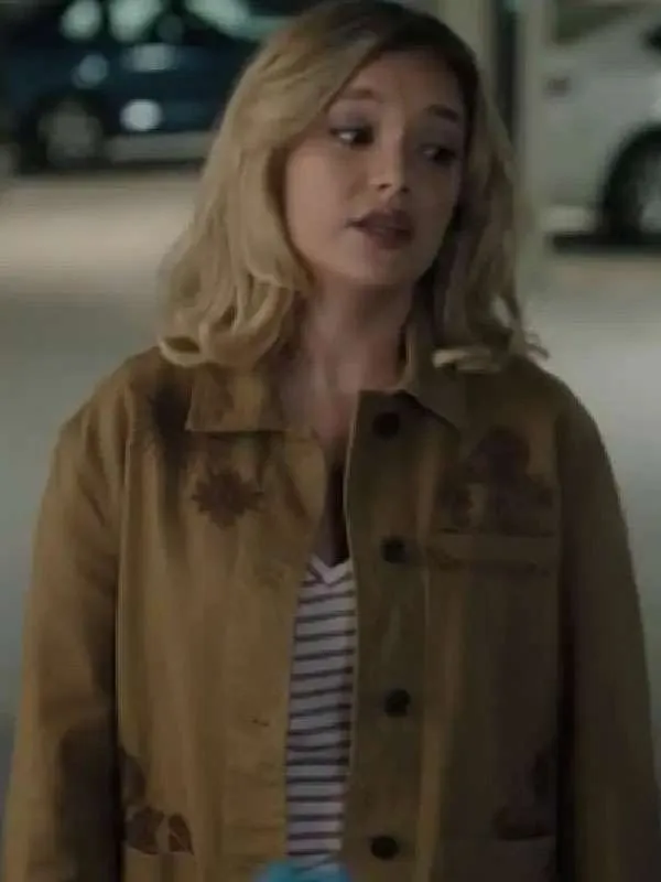 Live scene still of Amalia Williamson wearing the casual brown cotton embroidered jacket over a striped top in a dimly lit setting.