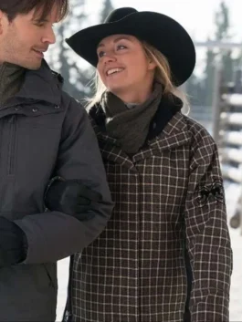 Close-up shot of Amber Marshall wearing a brown check plaid jacket with sleeve embroidery, paired with a black cowboy hat and scarf.