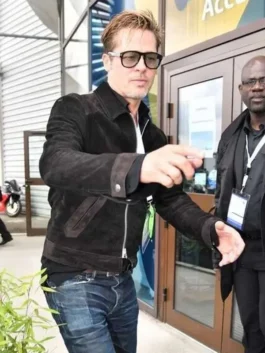 Brad Pitt walking outdoors wearing a black suede leather jacket with a silver full-front zipper, classic shirt collar, slant welt pockets, and tinted sunglasses.