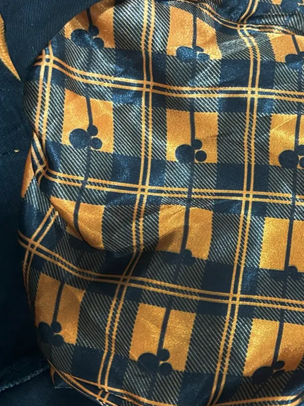 Close-up of the smooth inner lining of the Disney Mickey Mouse & Friends Halloween denim jacket, featuring a black and orange plaid pattern accented with small Mickey Mouse head shapes.