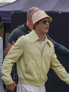 Side profile of Brad Pitt walking in a light yellow corduroy cotton jacket paired with a patterned bucket hat and aviator sunglasses.