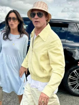 Three-quarter outdoor view of Brad Pitt wearing the pastel yellow corduroy cotton jacket with a white t-shirt, bucket hat, and sunglasses.