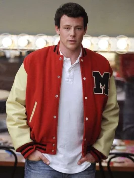 Front view of Finn Hudson played by Cory Monteith in Glee wearing a red varsity letterman bomber jacket over a white polo shirt.