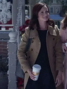 Alexis Bledel as Rory Gilmore standing outside in the snow holding a coffee cup, wearing a light brown double-breasted wool pea coat.