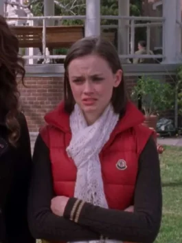 Rory Gilmore wearing a red and yellow colorblock padded puffer vest with a high collar and chest logo patch in Gilmore Girls.