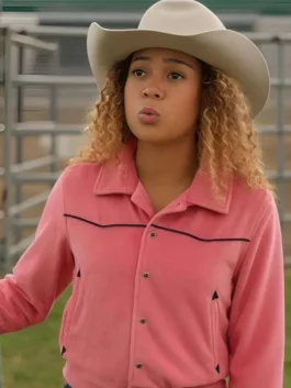 Kamaia Fairburn wearing a pink western jacket with black piped yoke detailing and snap button closures, paired with a beige cowboy hat.