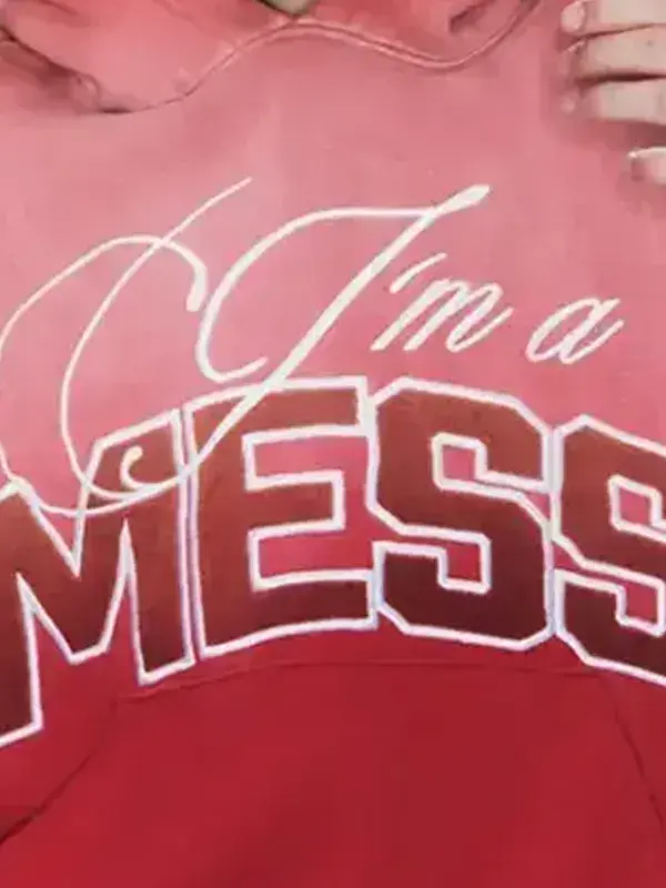 Close-up of the "I'm a MESS" chest graphic on a faded red and pink ombre pullover hoodie.