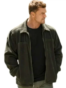 Alan Ritchson as Jack Reacher wearing a dark olive green cotton utility jacket with dual chest patch pockets and a shirt-style collar.