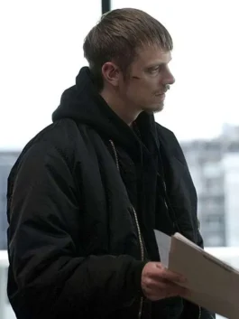 Side profile of Joel Kinnaman as Stephen Holder in The Killing wearing a black bomber jacket over a dark hoodie.