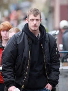 Front view of Joel Kinnaman walking outdoors wearing the Stephen Holder black bomber jacket with sleeve zipper pocket.