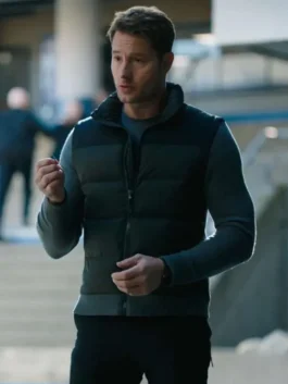 Front view of Justin Hartley as Colter Shaw wearing a two-tone grey and black puffer jacket with a stand-up collar.