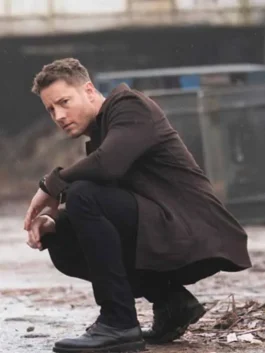 Side profile of Justin Hartley as Colter Shaw crouching in the Tracker S03 brown wool jacket.