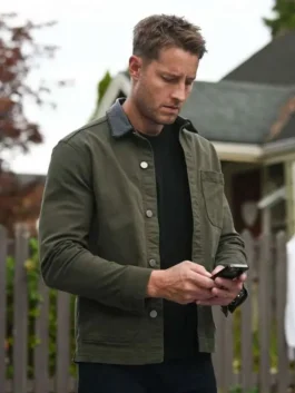 Justin Hartley checking his smartphone outdoor while wearing the Tracker Season 3 Colter Shaw green jacket.