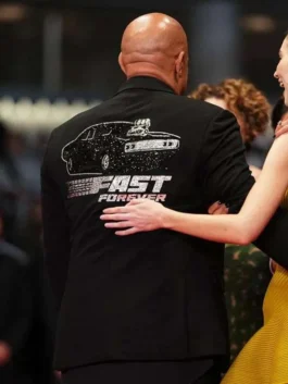 Rear view of Vin Diesel wearing a black blazer with a sparkling rhinestone design of a muscle car and "FAST FOREVER" text on the back.