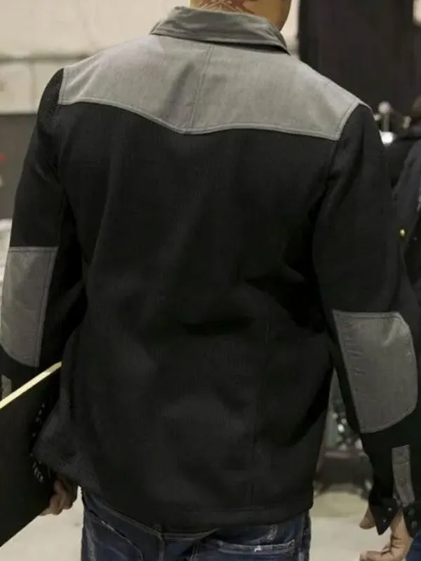 Rear view of the black and grey Xander Cage jacket, highlighting the contrast grey shoulder yoke and matching grey elbow patches on a black textured body.